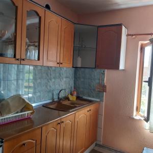波格拉德茨Guest House Pogradeci的一个带木制橱柜和水槽的厨房