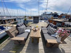 海利根港Hausboot Yara am Steg 1D的船上的天井设有沙发和桌子