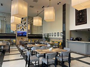库巴Arena Apartments & Villas Guba的用餐室配有桌椅和吊灯。