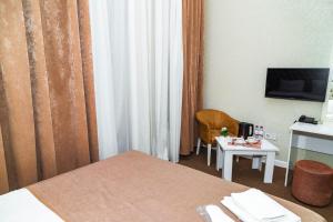 巴库Sahil Ark Hotel Baku的酒店客房设有一张床和一张小桌子。