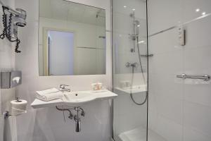 巴黎堡格林内尔埃菲尔铁塔酒店的白色的浴室设有水槽和淋浴。