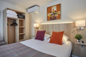 巴黎堡格林内尔埃菲尔铁塔酒店的卧室配有一张带两个枕头的大白色床