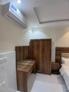 Quwayzahكيان التيسير للشقق المخدومة - Kayan Al Tayseer Serviced Apartments的一间卧室配有一张桌子和一张床