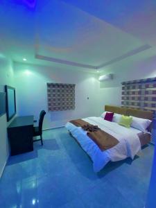 阿布贾lnfinity Luxury Apartment的一间卧室配有一张大床和一张书桌