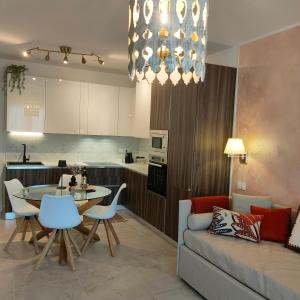BagnaiaSUITE ELEVEN ISOLA D'ELBA的厨房以及带沙发和桌子的客厅。