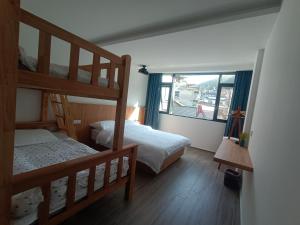 黄山风景区黄山望峰楼的一间卧室设有两张双层床和一扇窗户。