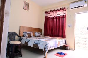 AyodhyaJankivihar Homestay at Prahladghat within 1km from Shri Ram Mandir的一间卧室配有床和红色窗帘