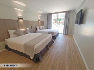 波拉马尔Hotel Margarita Dynasty的酒店客房设有两张床和窗户。