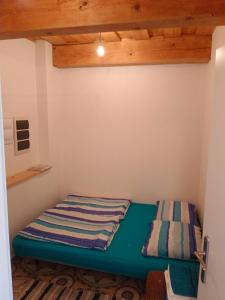 Chata U Jirky的一张小床,位于一个拥有木制天花板的房间