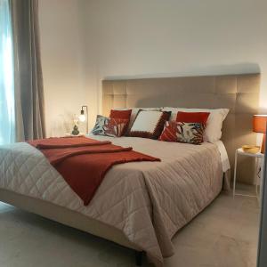 BagnaiaSUITE ELEVEN ISOLA D'ELBA的一间卧室配有一张带红色和白色枕头的大床