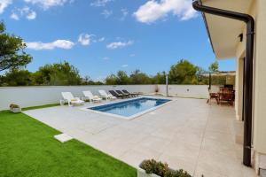 比利切Villa Shaula 1的后院设有游泳池和草坪