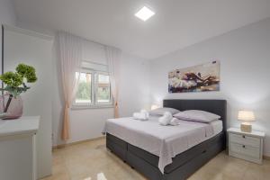 比利切Villa Shaula 1的一间卧室配有带2条白色毛巾的床
