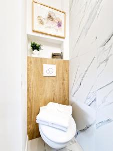 华沙J&W Apartments Grójecka Glam Flat的浴室设有白色卫生间和大理石墙壁。