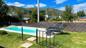 贝尔格拉诺将军镇La Calma的围栏旁带两把椅子的游泳池