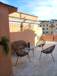 罗马Major House - Luxury Apartments的一座带三把椅子和一张桌子的庭院