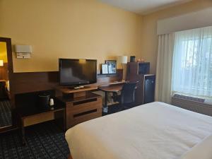 安克尼Comfort Inn & Suites Ankeny - Des Moines的酒店客房配有一张床和一张书桌及一台电视