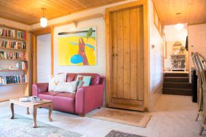 克拉佛斯Adelaide Hills Camellia Cottage Wifi的客厅配有红色的沙发和桌子