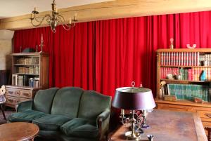 Manoir de Pimelles-Bourgogne-Chablis-2h15 Paris的客厅配有红色窗帘和椅子