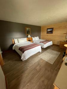 StrattonSpillover Motel and Inn的配有2张床的酒店客房,铺有木地板