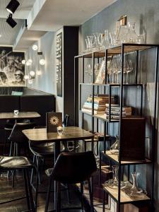 温特图尔Boutique Hotel Sonne Seuzach的一间带桌椅和玻璃架的餐厅