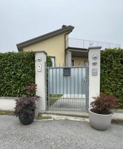 里瓦纳扎诺B&B Rivanazzano Tavernetta tra vino e terme的一座有门和两株盆栽植物的房子