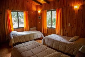 埃尔索韦维奥Lodge Paraíso的一间卧室配有两张床和橙色窗帘