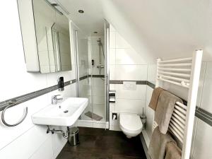 韦斯特雷费尔Kirchspielkrug Landhotel & Restaurant的白色的浴室设有水槽和卫生间。