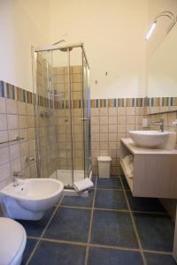 托雷圣乔万尼乌La Giara Resort的带淋浴、两个盥洗盆和卫生间的浴室