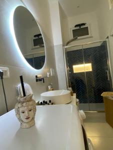 贾迪尼-纳克索斯Casa Don Saro的浴室设有镜子的柜台上的雕像