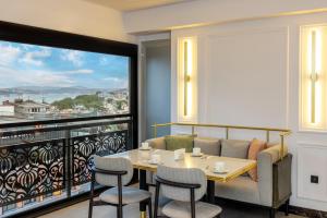 伊斯坦布尔Rast Hotel Sultanahmet的一间带桌椅和大窗户的用餐室