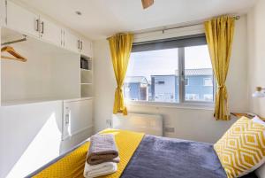 彭布罗克郡Beach Woods Coastal Path chalet的一间卧室设有黄色的床和窗户。