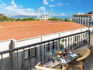 伊斯坦布尔Rast Hotel Sultanahmet的屋顶阳台配有桌椅