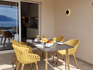 洛帕Haus Mit Meerblick的餐桌、黄色椅子和餐桌