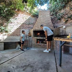 瓜伊马延Mendoza - Casa Cardozo的站在砖炉前的男人和男孩