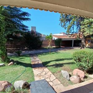 瓜伊马延Mendoza - Casa Cardozo的后院,带草坪和房子
