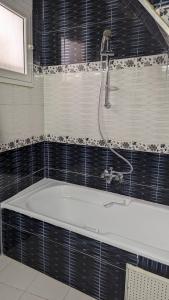 苏塞Maison de ville sousse的浴室设有浴缸和淋浴。