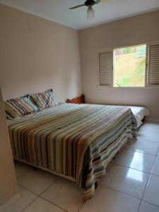 帕苏斯Rancho Tamanduá的一间卧室设有一张大床和窗户