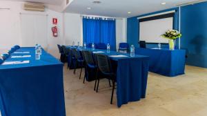 圣伊西德罗Hotel Aeropuerto Sur的一间会议室,配有蓝色的桌椅