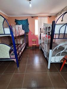 奥鲁罗Backpacker Oruro的客房设有三张双层床,铺有瓷砖地板。