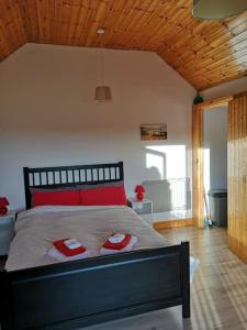 威克洛Sunriseview Cottages的一间卧室配有一张带两个红色枕头的床