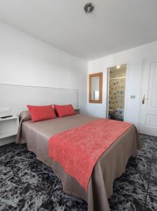 桑亨霍Apartamentos Faxilde的一间卧室配有一张带红色枕头的大床
