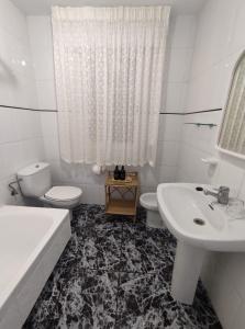 桑亨霍Apartamentos Faxilde的白色的浴室设有水槽、卫生间和浴缸。