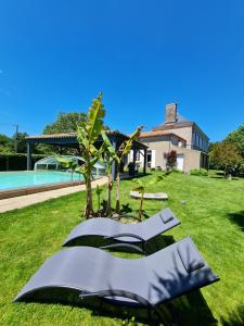 永河畔拉罗什Chambre d'hôte BALI的一座花园,花园旁设有两把椅子和一棵树
