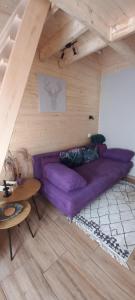 鲍科尼贝尔Borostyánkút Wellness Home Bakonybél的客厅配有紫色沙发和桌子