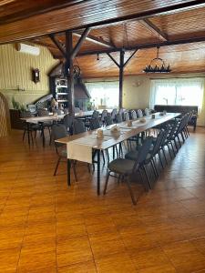 布沃涅Zajazd Restauracja Derby的大型用餐室配有长桌和椅子