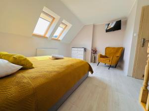 克雷尼察Górska Przystań SPA的一间卧室配有黄色的床和黄色的椅子