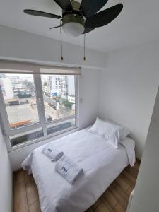 利马Acogedor 2BR Miraflores - Tovar的卧室配有白色的床和吊扇