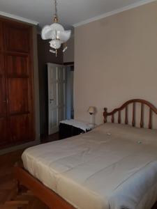 瓜伊马延Mendoza - Casa Cardozo的卧室配有一张带吊灯的大型白色床。
