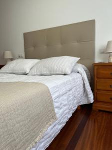 博伊罗Piso Barbanza Arousa的一间卧室配有一张大床和一个木制梳妆台
