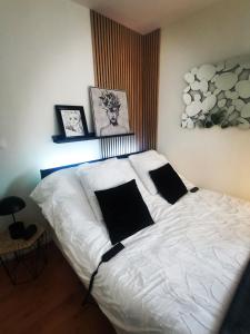 塞讷塞迪容L'atelier de Jane的卧室配有白色的床和两个枕头